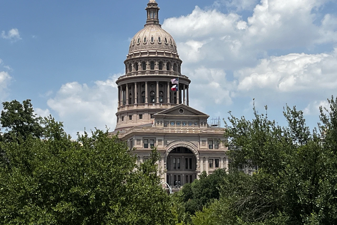 Texas Capitol framed by trees.